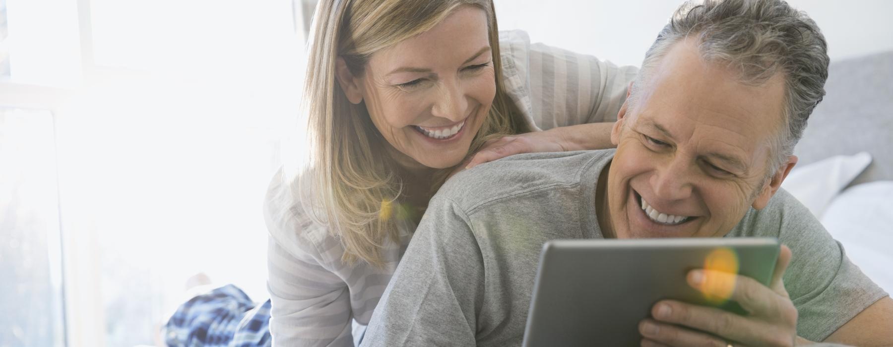 a woman and a man looking at a tablet